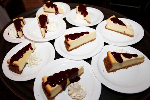 Triangle slices of cheesecake at a party or restaurant with chocolate sauce