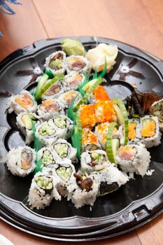 Delicious looking california rolls and other varieties of sushi on a plastic tray
