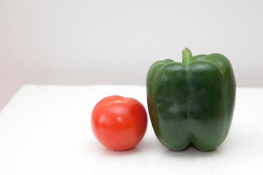 beautiful round ripe tomato and sweet green pepper