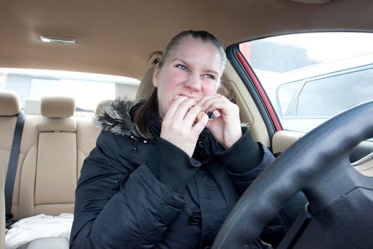  a woman hungrily eats fast food in her car