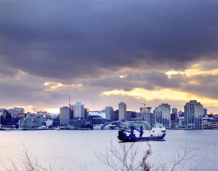 December 11, 2013: Halifax, Nova Scotia- a cargo vessel sits in the Halifax Harbour with the city behind it 