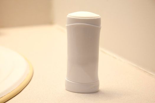 A white stick of antiperspirant or deoderant on the bathroom counter