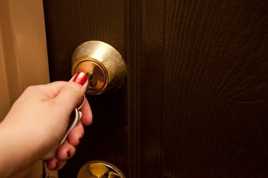Hand locks or unlocks the door to an apartment or room 