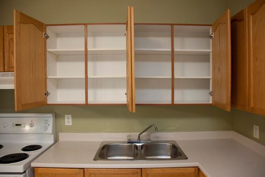  Kitchen counter beside a kitchen sink with two empty cabinets above in a home or apartment