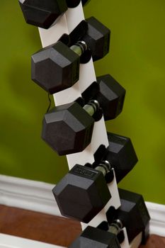 5, 10 and 15 pound dumbells on a rack at a home gym 