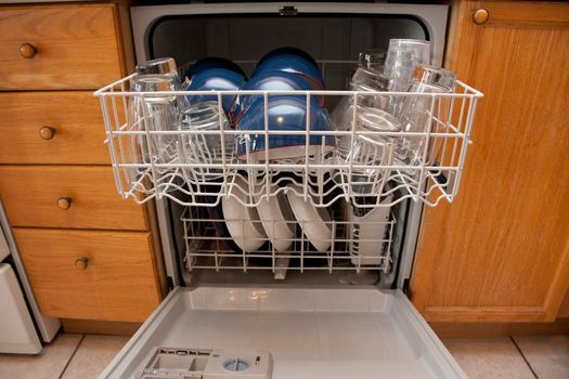 A dishwasher full of dirty or clean dishes in a home or apartment 