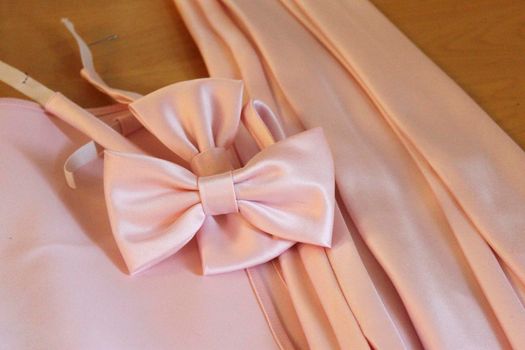 Men's wear ready for a formal event, pink satin bowties and neck ties