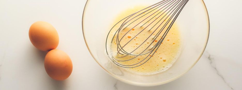 Cooking, meal and diet concept - Making of mixing eggs in bowl on marble table as homemade food flat lay, top view food brand photography flatlay and recipe for cooking blog, menu or cookbook design