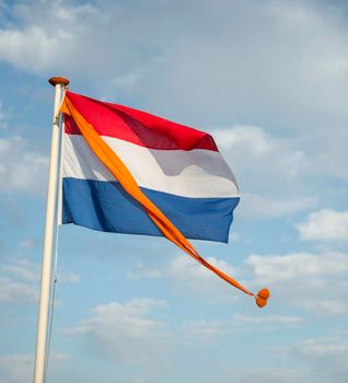 Dutch flag, red, white and blue with the orange pennant of the Royal Kingdom at the birthdayor kingsday of King Willem-Alexander