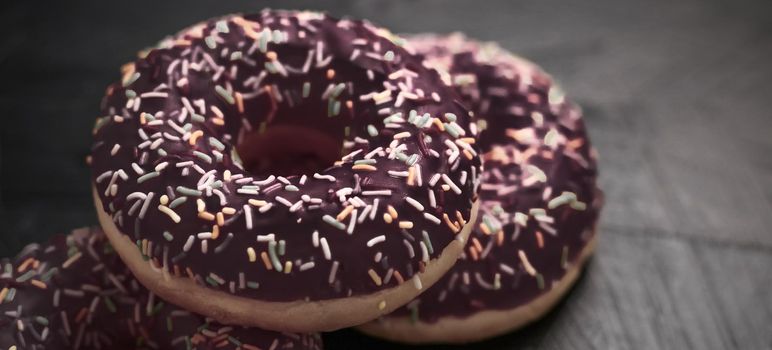 Bakery, branding and cafe concept - Frosted sprinkled donuts, sweet pastry dessert on rustic wooden background, doughnuts as tasty snack, top view food brand flat lay for blog, menu or cookbook design