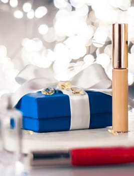 Cosmetic branding, Christmas glitter and girly blog concept - Holiday make-up foundation base, concealer and blue gift box, luxury cosmetics present and blank label products for beauty brand design