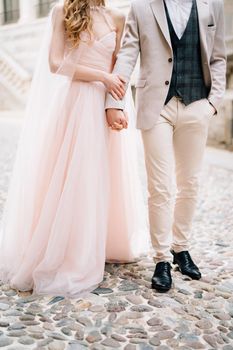 Newlyweds stand on paving stones against the background of an old building in Bergamo, Italy. High quality photo