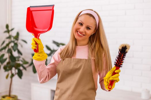 Beautiful housewife enjoys cleaning  her home.