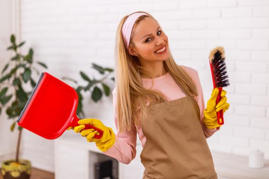 Beautiful housewife enjoys cleaning  her home.