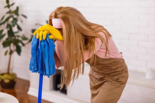 Tired housewife cleaning her home.