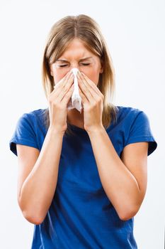 Young woman is having flu and she is blowing her nose