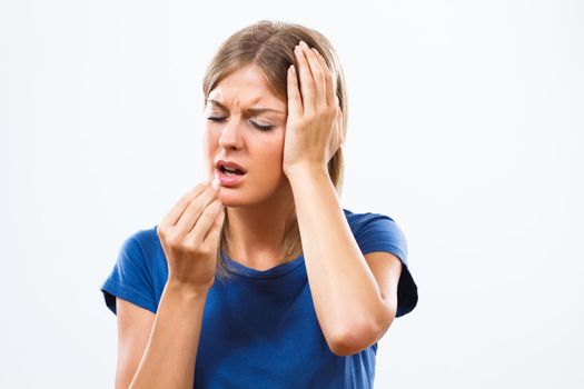 Young woman is having a headache and taking pill
