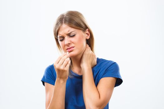 Young woman is taking pills for pain in neck	.