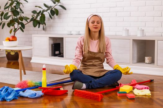 Housewife took a break to meditating while cleaning her home.