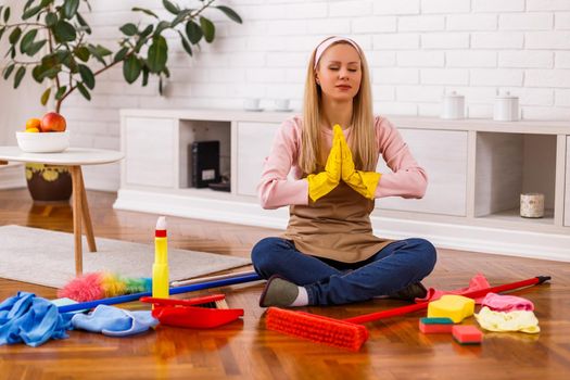 Housewife took a break to meditating while cleaning her home.