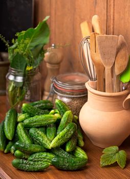 Food background. Cucumbers with garlic, salt, dill and empty glass jar for pickling over old wooden surface. Top view