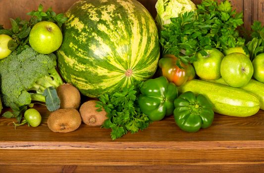 Useful green vegetables on a wooden background