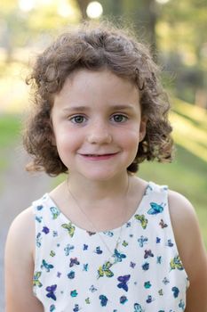 portrait of a young girl with curly hair in a butterfly dress