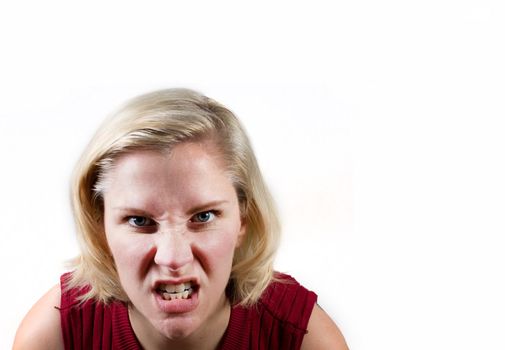 a woman makes an extremely angry or determined face in white studio background with copy space 
