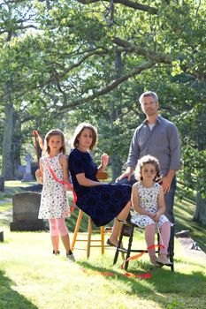  a sad looking family in the cemetery with serious expressions 