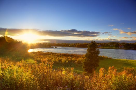 Beautiful sunset over river with autumn trees in foreground, Sydney, Nova Scotia, Canada.