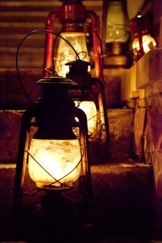  old fashioned oil lamps or lanterns sitting on a flight of stairs at night