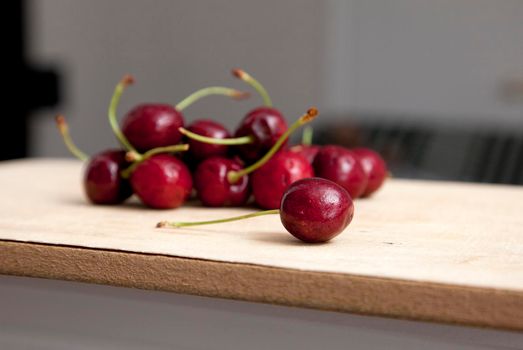  group of dark cherries on a cutting board in kitchen 