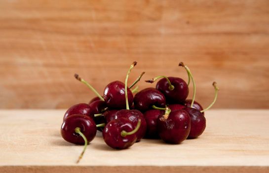 beautiful dark red or black cherries against a wooden board, ready for eating