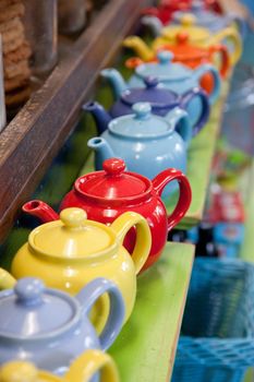 a row of colorful teapots lined up inside a restaurant  