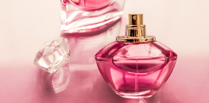 Perfumery, spa and branding concept - Pink perfume bottle on glossy background, sweet floral scent, glamour fragrance and eau de parfum as holiday gift and luxury beauty cosmetics brand design