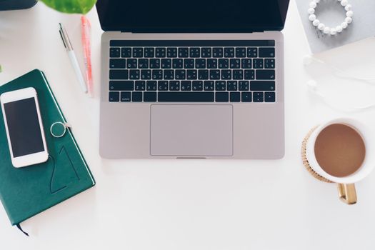 Top view of modern laptop or notebook with phone to work. Office desktop on table background.