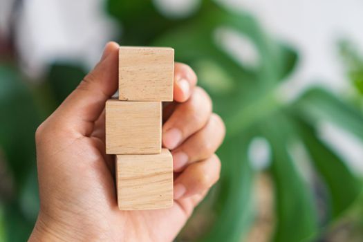 Blank wooden cube that you can put text or icon on in hand hold background. 