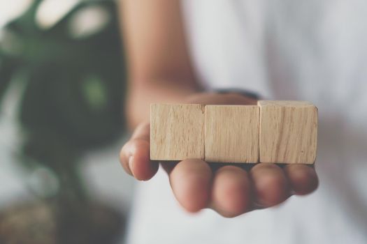 Blank wooden cube that you can put text or icon on in hand hold background. 