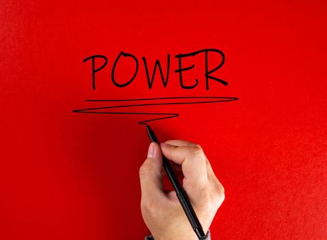 Hand writing the word power on red background. Attaining power in business or life concept.