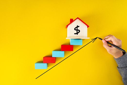 businessman drawing an arrow up above the houses. The concept of growth in demand for real estate and Increase in the value of property,