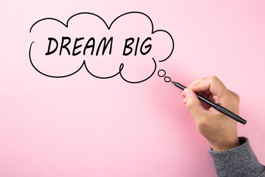 Hand writing Dream Big in cloud bubble on pink background