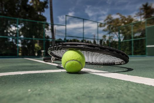 Tennis ball and racket on the dross cort. Lifestyle or hobby, sport or entertaiment