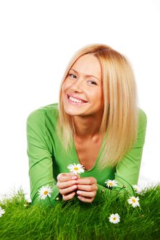 Beautiful young blonde woman lying on grass with chamomile flowers, isolated on white background