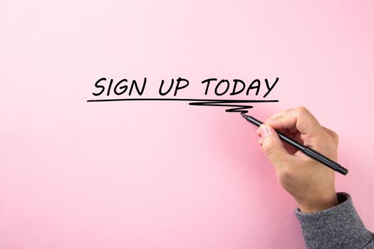 Hand writing a word SIGN UP TODAY on pink background.