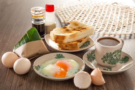 Common oriental breakfast set in Malaysia consisting of coffee, nasi lemak, toast bread and half-boiled egg