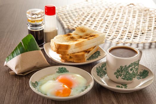 Common oriental breakfast set in Malaysia consisting of coffee, nasi lemak, toast bread and half-boiled egg