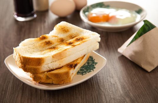 Common oriental breakfast set in Malaysia consisting of coffee, nasi lemak, toast bread and half-boiled egg