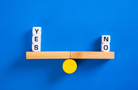 Yes vs No. Choice concept. Balance scales on blue background. Close up.