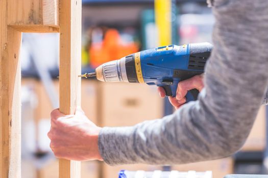 Do it yourself home handyman is using a cordless screwdriver for screwing