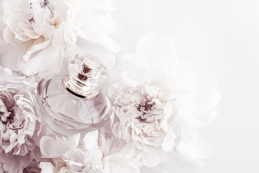 Chic fragrance bottle as luxe perfume product on background of peony flowers, parfum ad and beauty branding design